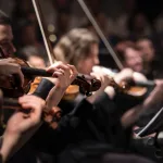 people playing violin inside dim room