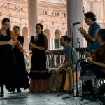 woman in black dress standing beside man in black shirt