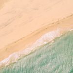 an aerial view of a sandy beach and ocean