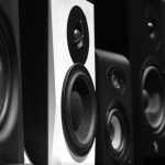 black and gray speakers on brown wooden table